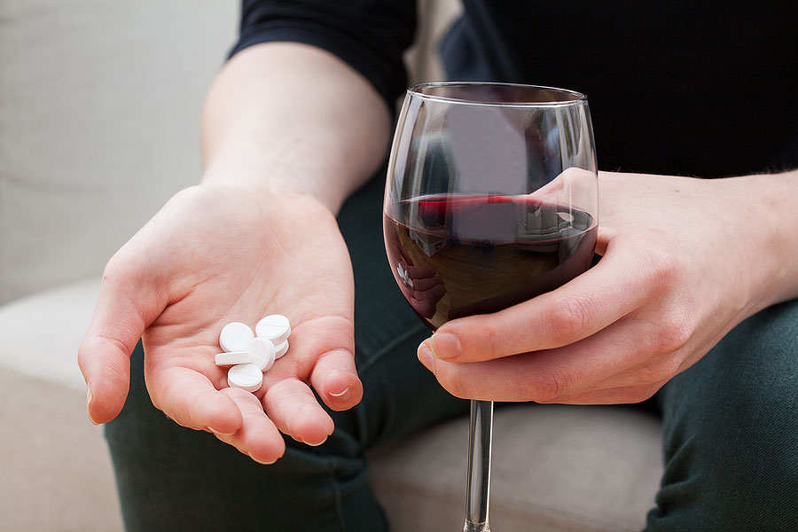 Woman taking medicine and wine