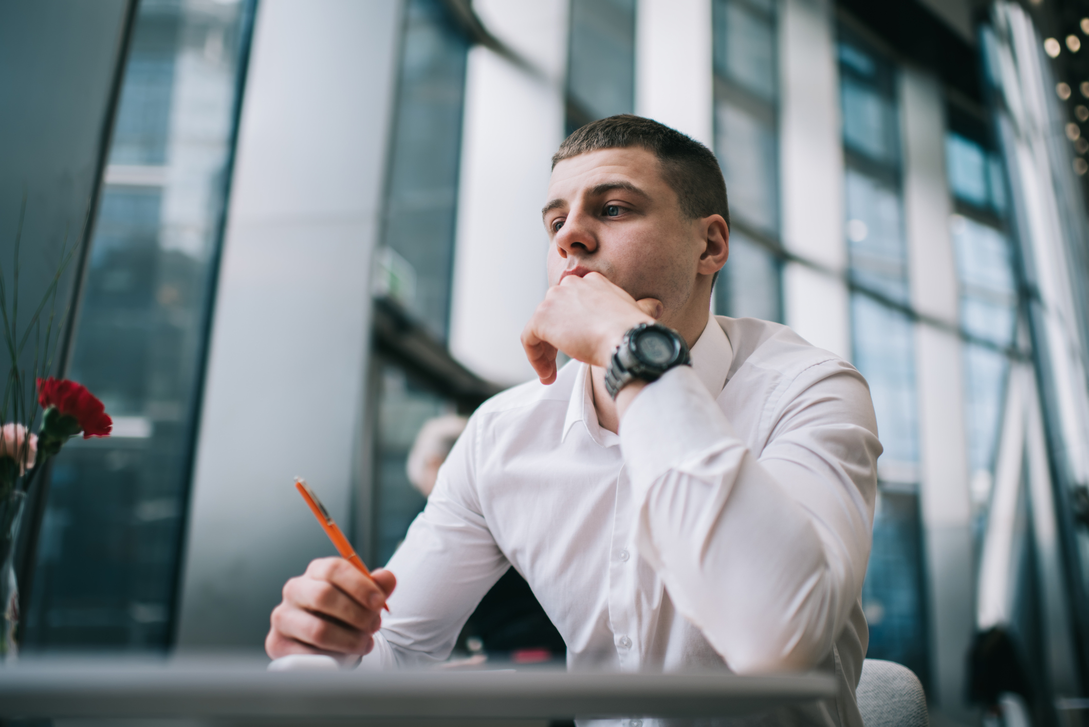 Thoughtful man writing thoughts in notebook