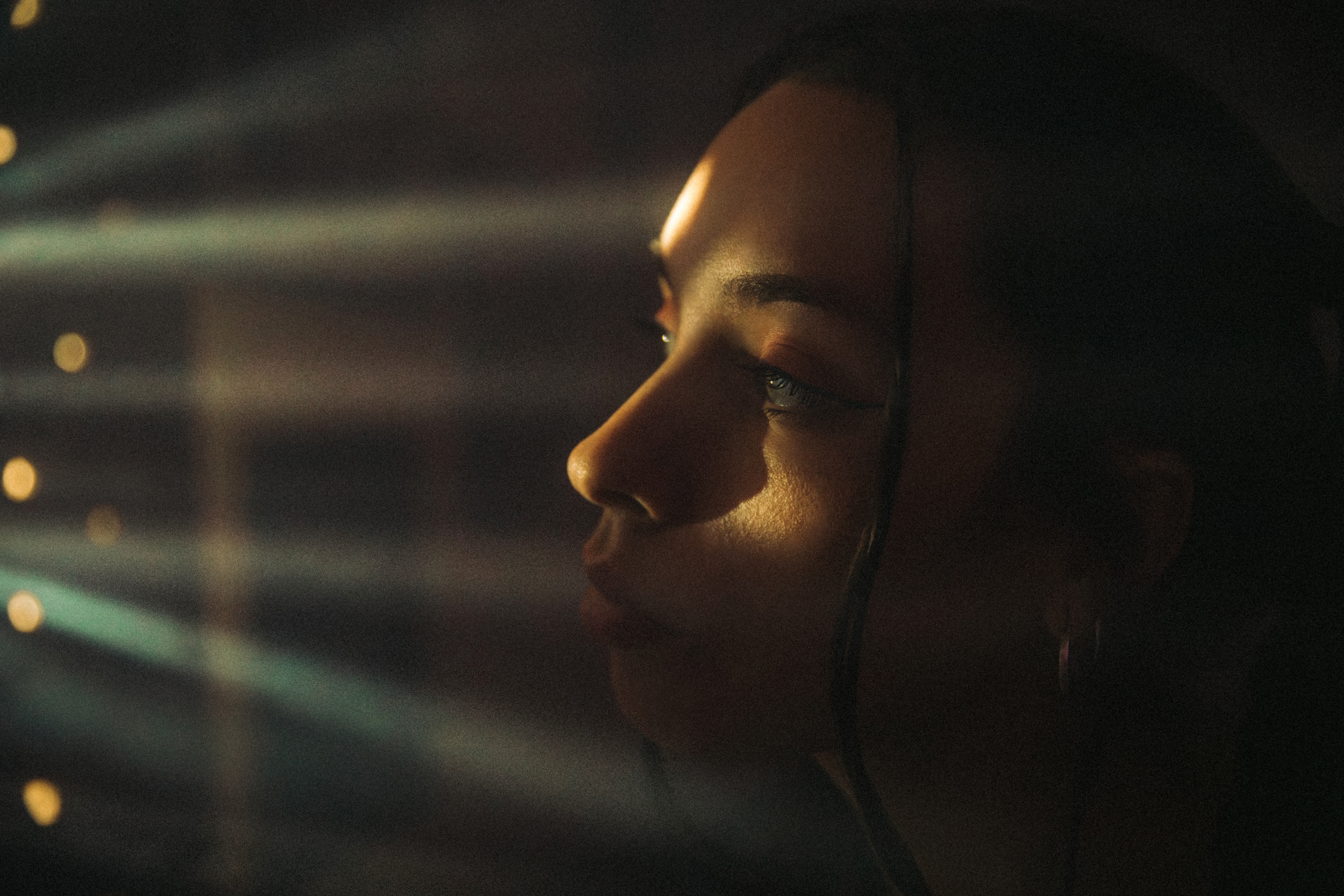 Woman looks through a hole that emanates light