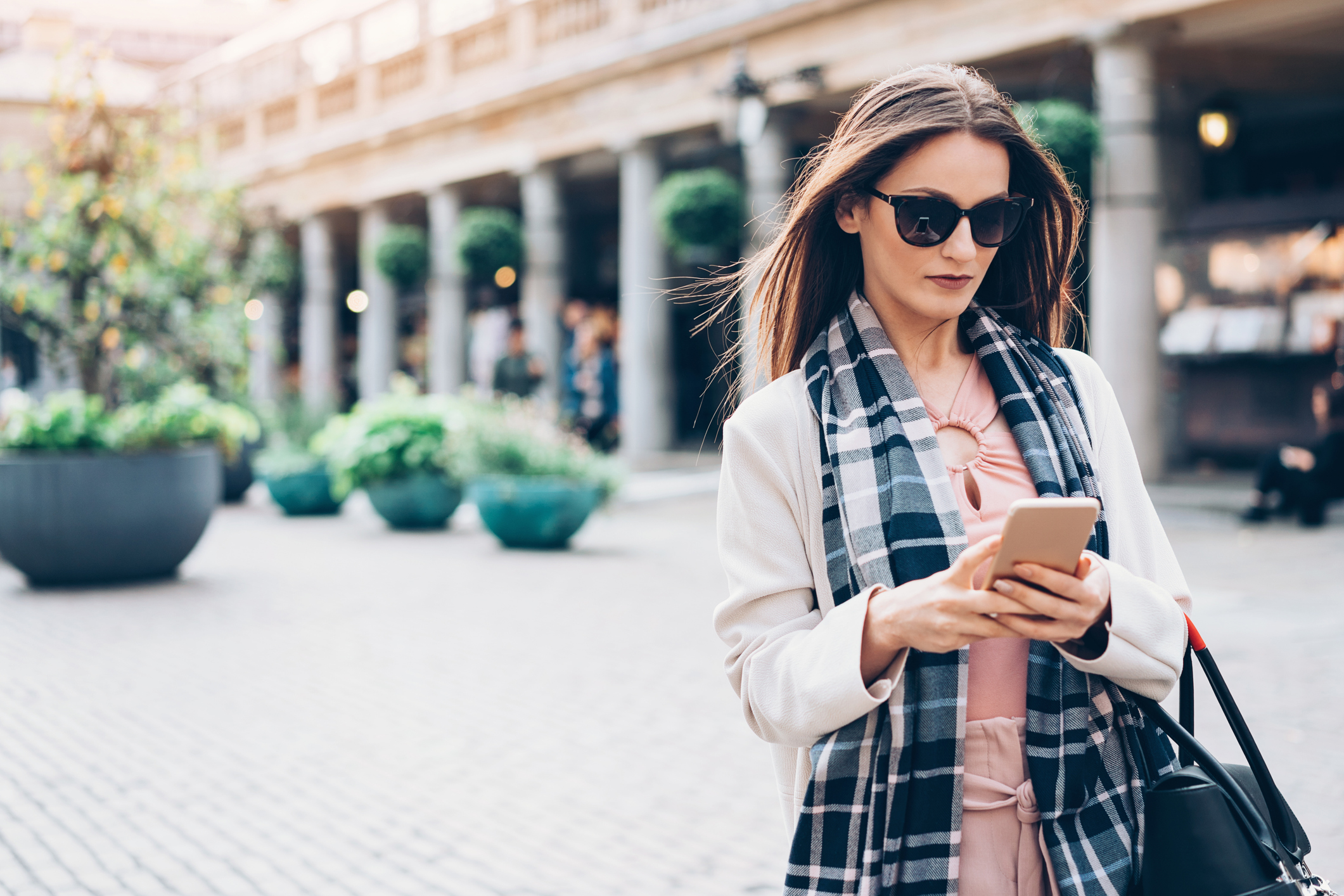 Fashionable city woman texting on the street